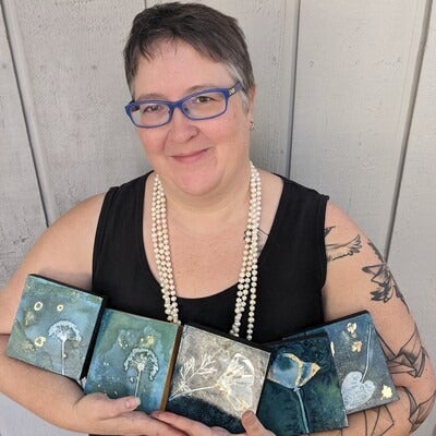Jessie Swimeley holding pieces of her art